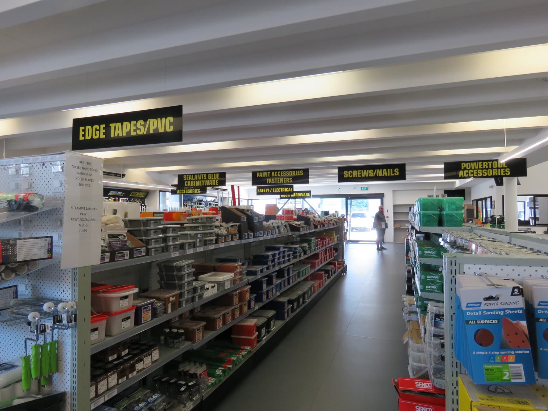 The trading floor in use, with aisle signage overhead and a customer at the entrance.